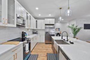 a kitchen with white cabinets and stainless steel appliances at Comfy Room Downtown Indy in Indianapolis +25 photos