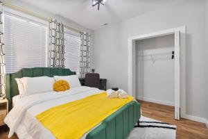 a bedroom with a large bed with a yellow blanket at Comfy Room Downtown Indy in Indianapolis