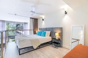 パーム・コーブにあるHotel Drift 3201 Beachfront Accomodationの大きなベッドとバルコニーのある寝室