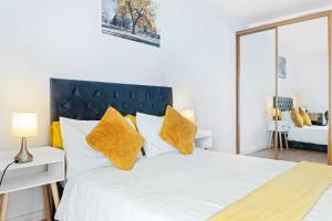 a bedroom with a large white bed with yellow pillows at Grand Central , 2 double bedroom apartment with free parking , Birmingham in Birmingham