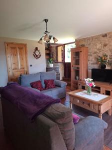 a living room with a couch and a table at La Cabaña del Abuelo en la aldea cerca del mar in Santa Marta de Ortigueira