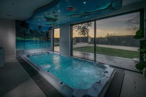 Cette chambre dispose d'une grande baignoire et d'une piscine. dans l'établissement Luxury 7 Bed Durham Mansion Pool, Spa, Cinema, à Durham