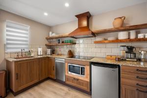 a kitchen with wooden cabinets and stainless steel appliances at Secluded Luxury Couples cabin Sauna Pool in Wimberley