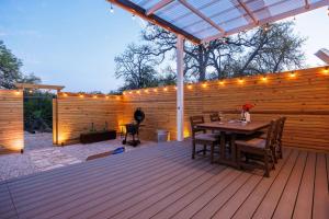 a wooden deck with a table and lights on it at Secluded Luxury Couples cabin Sauna Pool in Wimberley