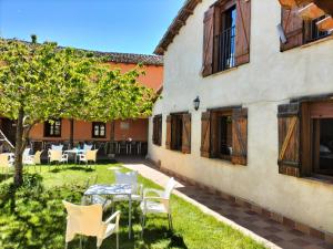 patio ze stołami i krzesłami obok budynku w obiekcie Don Camino Low Cost w mieście Villalcázar de Sirga