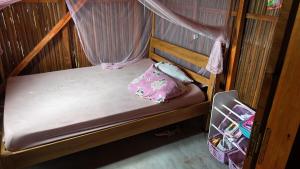 a small bunk bed with a mosquito net at Chez falisoa in Nosy Be