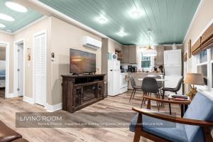 a living room with a television and a dining room at Mills Cottage in Orlando +15 photos