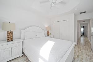 a white bedroom with a white bed and a lamp at Free Golf Cart & Netflix Included - 2 Mins to Brownwood Paddock-Sleeps 6 in The Villages
