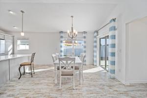 a dining room with a white table and chairs at Free Golf Cart & Netflix Included - 2 Mins to Brownwood Paddock-Sleeps 6 in The Villages