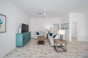 a living room with a couch and a tv at Free Golf Cart & Netflix Included - 2 Mins to Brownwood Paddock-Sleeps 6 in The Villages