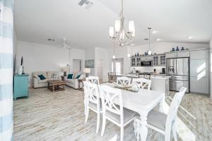 a kitchen and living room with a white table and chairs at Free Golf Cart & Netflix Included - 2 Mins to Brownwood Paddock-Sleeps 6 in The Villages