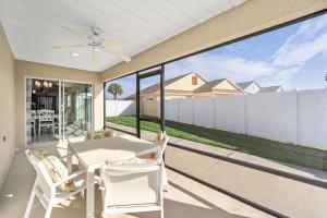 a screened porch with a table and chairs and a ceiling fan at Free Golf Cart & Netflix Included - 2 Mins to Brownwood Paddock-Sleeps 6 in The Villages