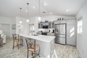 a kitchen with white cabinets and a kitchen island with chairs at Free Golf Cart & Netflix Included - 2 Mins to Brownwood Paddock-Sleeps 6 in The Villages