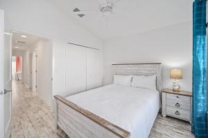 a white bedroom with a bed and a night stand at Free Golf Cart & Netflix Included - 2 Mins to Brownwood Paddock-Sleeps 6 in The Villages