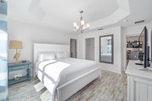 a white bedroom with a white bed and a sink at Free Golf Cart & Netflix Included - 2 Mins to Brownwood Paddock-Sleeps 6 in The Villages