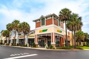 a building with palm trees in front of a street at Free Golf Cart & Netflix Included - 2 Mins to Brownwood Paddock-Sleeps 6 in The Villages