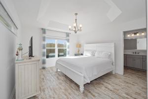 a white bedroom with a bed and a television at Free Golf Cart & Netflix Included - 2 Mins to Brownwood Paddock-Sleeps 6 in The Villages