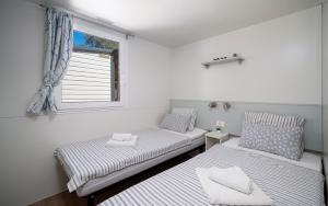 ビオグラード・ナ・モルにあるAZURA Mobile Home, Biograd na Moruの窓のある部屋にツインベッドが2台