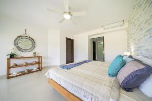 une chambre avec un lit et une horloge au mur dans l'établissement Luxury 2 BR Condo with tub & Infinity Pool - Beach Side At Mareazul - Sirenita G, à Playa del Carmen