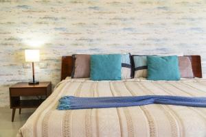 une chambre avec un lit avec des oreillers bleus dans l'établissement Luxury 2 BR Condo with tub & Infinity Pool - Beach Side At Mareazul - Sirenita G, à Playa del Carmen