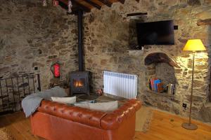 a living room with a leather couch and a fireplace at Casal do Amor in Lousã