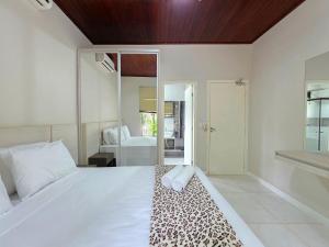 a bedroom with a white bed with a leopard print rug at 7 quartos - ótima área de lazer prox Centro e Cataratas in Foz do Iguaçu +62 photos