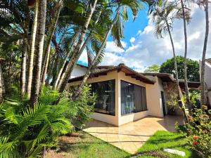 a house with palm trees in front of it at 7 quartos - ótima área de lazer prox Centro e Cataratas in Foz do Iguaçu