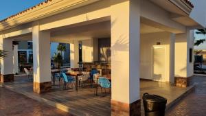 マサトランにあるPrecioso Departamento equipado con alberca y minigolfのパティオ(デッキの椅子とテーブル付)