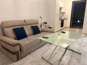 a living room with a couch and a glass table at Appart'hotel61 OFFRE D'OUVERTURE Au pied de tous commerces & commodités ainsi que marché mercredi & samedi in Flers