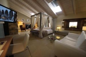 a bedroom with a bed and a couch and a tv at La Posada de Mosqueruela in Mosqueruela