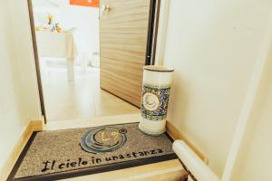 a door mat in front of a door with a cup at Ellenove holiday house in Tortoreto Lido