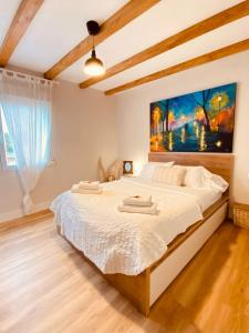 a bedroom with a large bed with a painting on the wall at El Hogarin de Veronica in Gijón