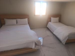 two beds sitting next to each other in a bedroom at Hotel Restaurant Bougafer in Midelt