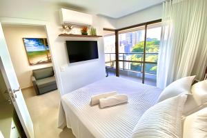 a bedroom with a bed with a tv and a balcony at Capitães de Areia in Salvador +119 photos