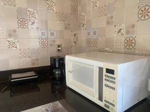 a microwave oven sitting on a counter in a kitchen at Casa do Sol in Tibau do Sul