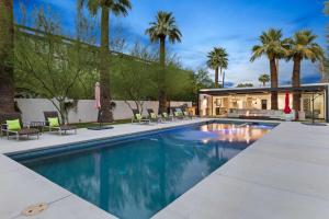 a swimming pool with chairs and palm trees at Arcadia Beach Club - 4-Villa Luxe Retreat with Pool in Phoenix