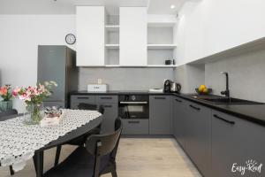 una cucina con tavolo e una cucina con tavolo e sedie di Przy plaży Apartament 206 - Rezydencja Niechorze - Easy - Rent Apartments a Niechorze Altre 40 foto