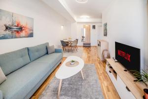 un soggiorno con un divano blu e un tavolo di Luxury Flat in Ohrid Center Near Lake & Old Town a Ohrid
