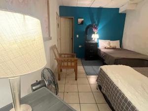 Una habitación de hotel con dos camas y una lámpara. en casa de elena, en Santa Ana