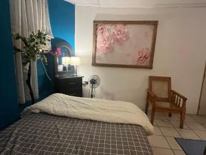 Un dormitorio con una cama y una silla y un cuadro. en casa de elena, en Santa Ana 3 fotos más