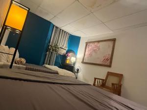 a bedroom with a large bed with blue walls at casa de elena in Santa Ana