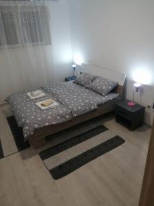 a small bedroom with a bed and a table at Apartman Una in Soko Banja