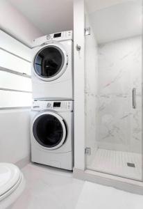 a washer and dryer in a bathroom with a toilet at 4BD 2BA - Black&White ArtBNB - Antique Row WPB in West Palm Beach