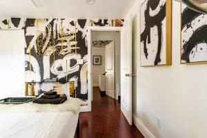 a bedroom with a bed and a wall with art at 4BD 2BA - Black&White ArtBNB - Antique Row WPB in West Palm Beach