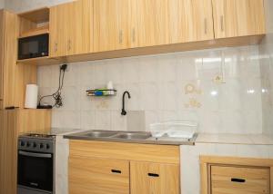 a kitchen with a sink and a stove at The nest Léo 2000 in Kpoti