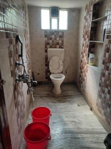 a bathroom with a toilet and buckets in it at Luxury penthouse on budget in Kolkata