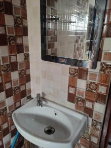 a bathroom with a white sink and a mirror at Luxury penthouse on budget in Kolkata