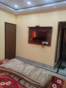a bedroom with a bed and a tv on the wall at Luxury penthouse on budget in Kolkata
