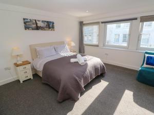 a bedroom with a bed with a stuffed animal on it at Flat 1 in Penzance