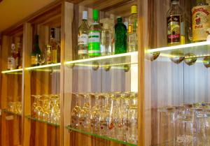 a cabinet filled with glasses and bottles of alcohol at ITM Hotel an der Bille in Hamburg